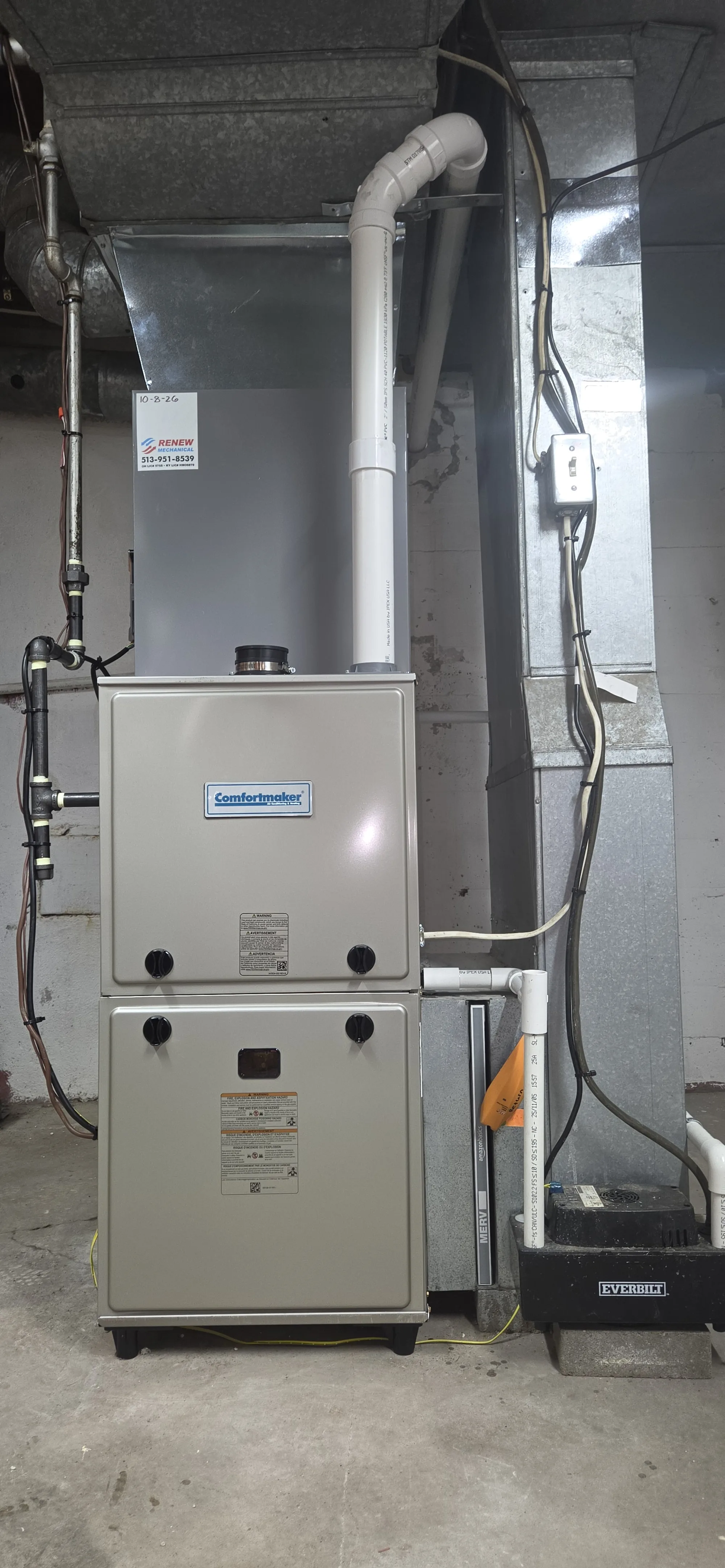 60,000 BTU 96% efficiency furnace with a white PVC vent pipe and a condensate pump in a utility room, HVAC job in Covington, KY.