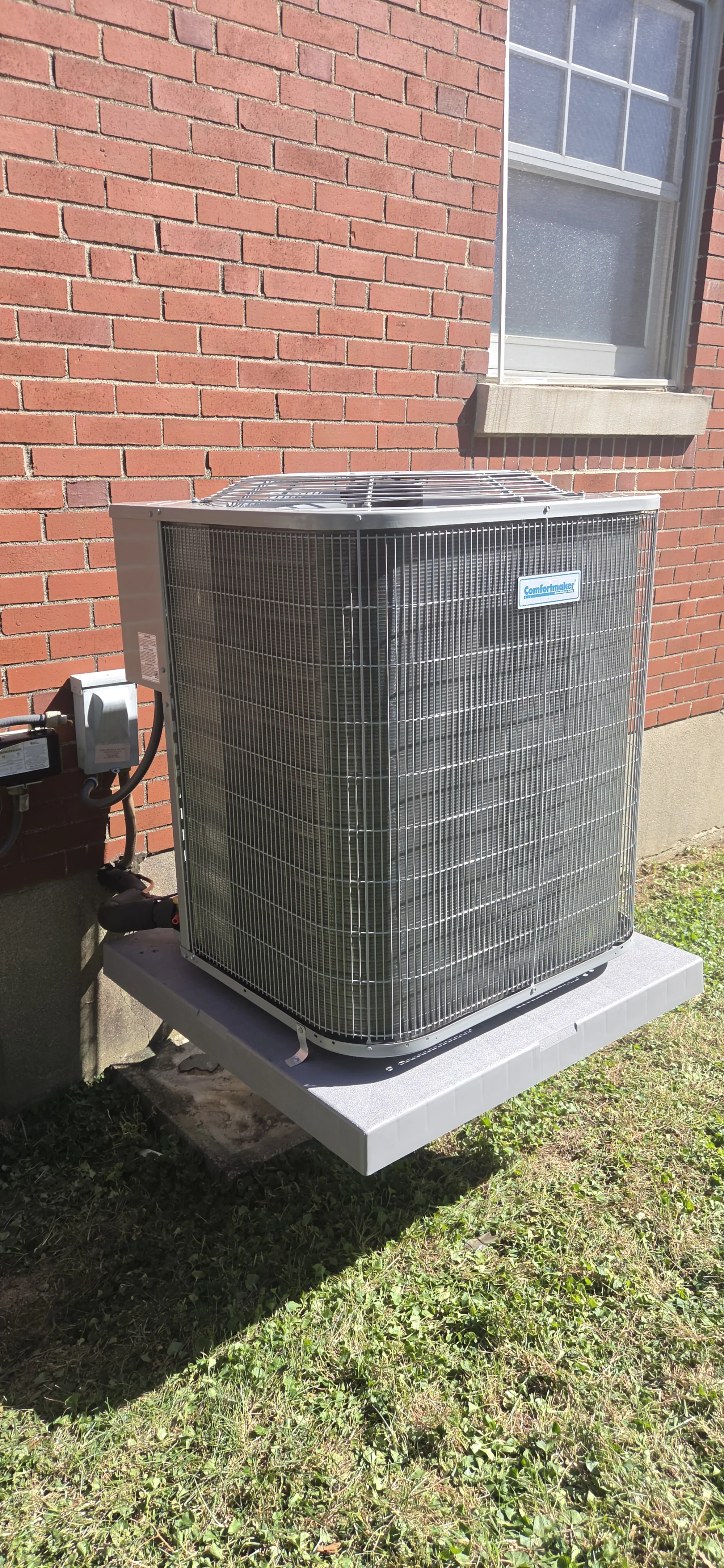2.5 ton 14.3 SEER2 AC outdoor unit on a pad beside a brick wall, HVAC job in Covington, KY.