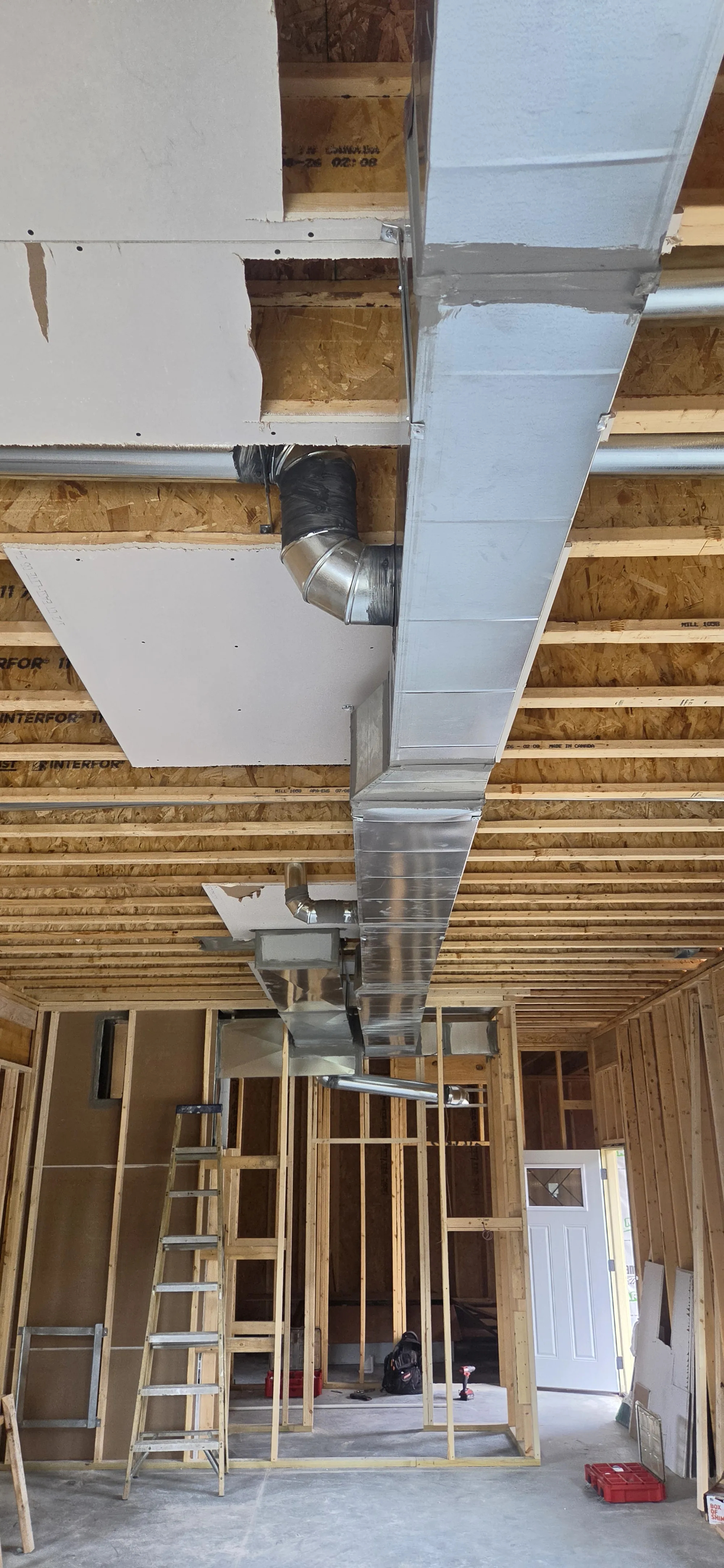 New sheet metal duct trunk line run along the ceiling joists of a framed new home, new home HVAC in Cincinnati, OH.