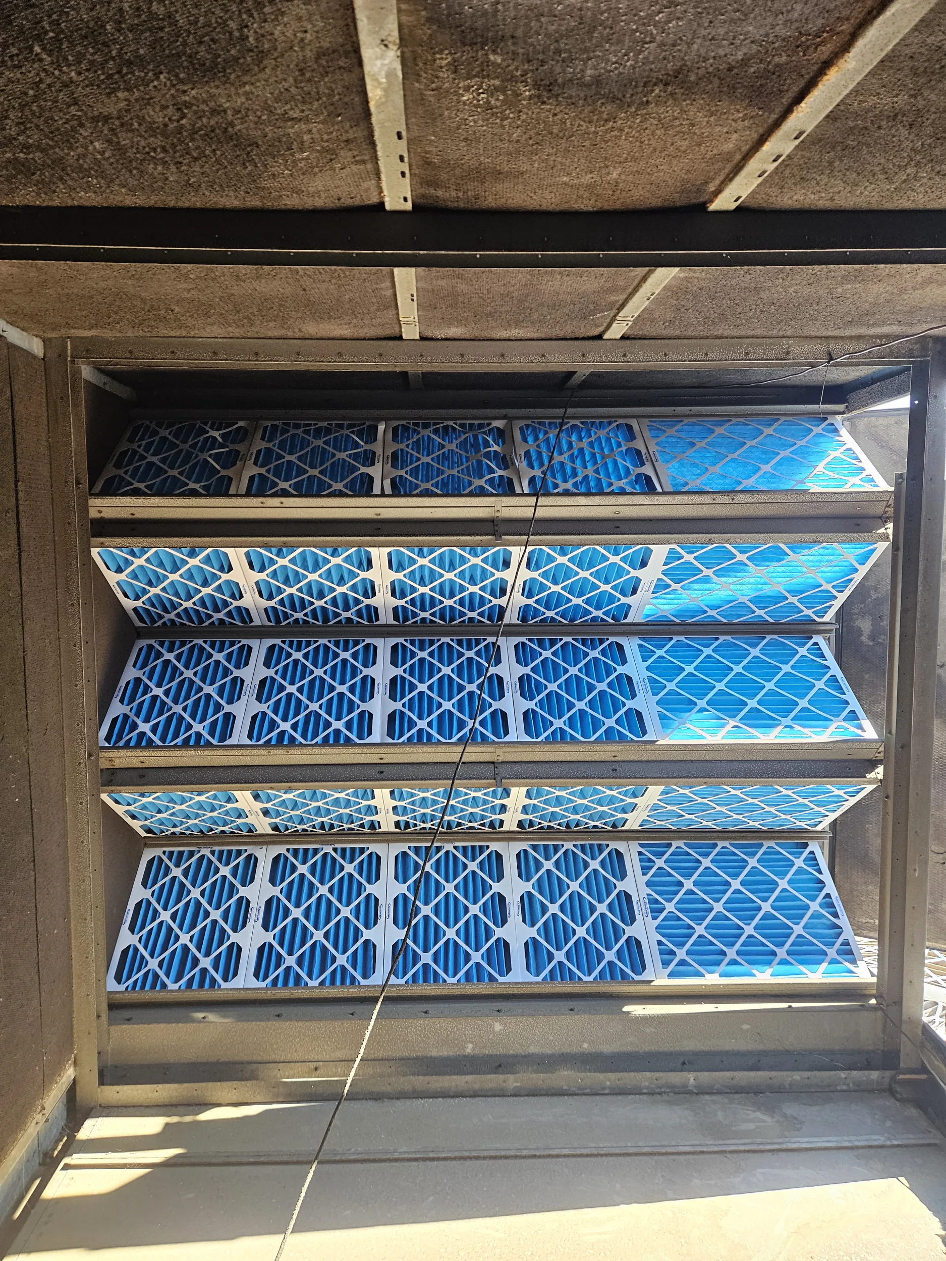 Rows of new pleated air filters inside a commercial rooftop unit, RTU repair in Cincinnati, OH.