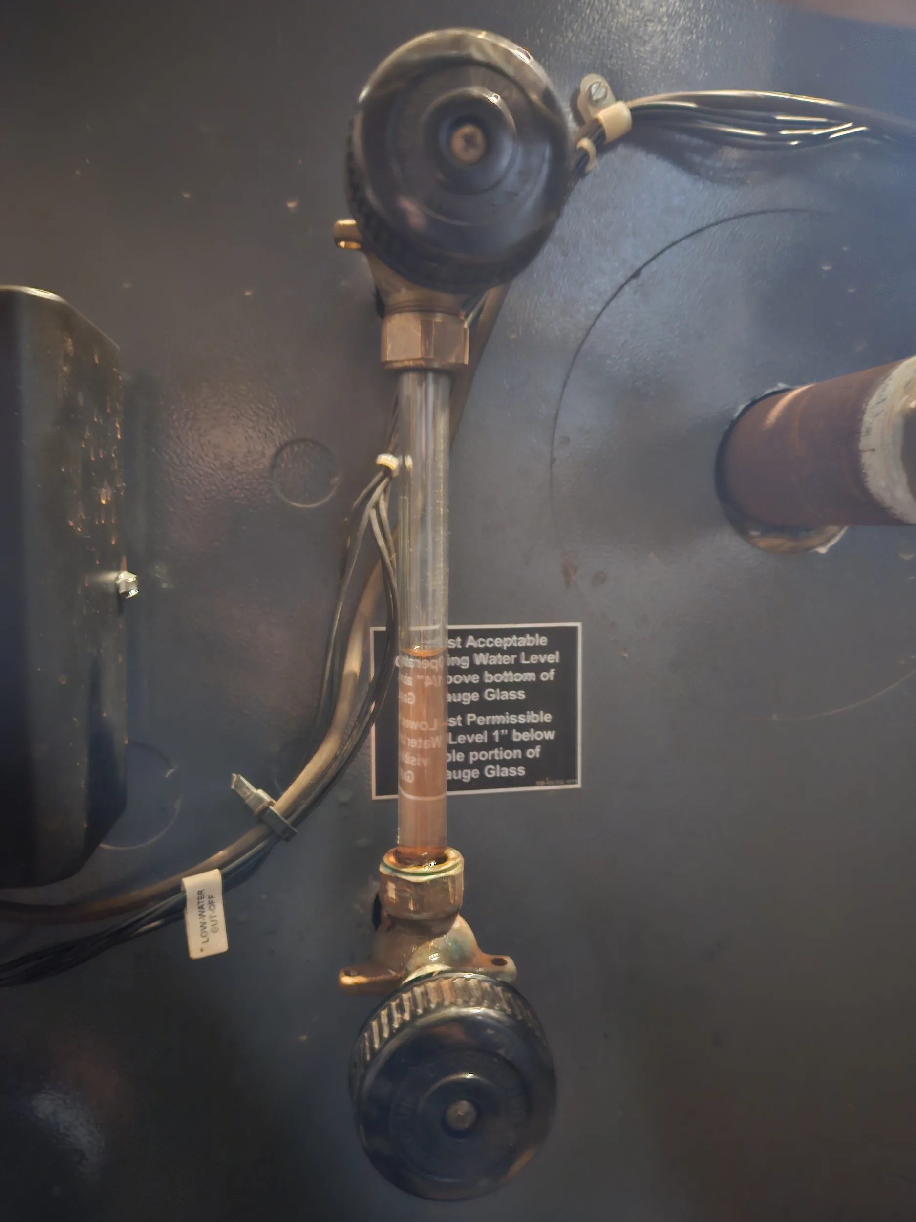 Sight glass gauge on the side of a steam boiler with its water level label, steam boiler repair in Cincinnati, OH.